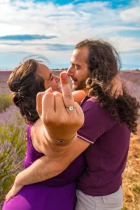 Photographe de mariage 04 - Les mariés s'embrassent dans un champs de blé a valensole, la mariée mets en gros plan son doigt avec l'alliance, Alpes-de-Haute-Provence