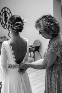 Photographe de mariage 04 - La maman de la mariée l'aide a fermer sa robe, préparatifs de mariage en Alpes-de-Haute-Provence