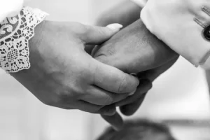 Photographe de mariage 04 - Gros plan des mains qui se tiennent pendant l'échange des voeux a l'église, Alpes-de-Haute-Provence