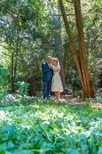 Photographe mariage - Couple de mariés enlacés dans une forêt lumineuse lors d'une séance photo en extérieur