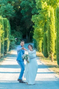 Photographe mariage Bouches-du-Rhône - Séance photo fun, mariés s'avançant en riant dans une allée de cyprès