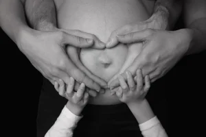 famille avec enfant qui tient tous le ventre de maman qui est enceinte - le petit garçon soutient le ventre de maman par le bas