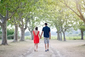 Couple qui se promene en se tenant la main dans une grande allée d'un chateau du var