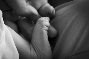 Papa qui tient le petit pied de son enfant nouvellement né
