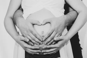 deux paires de mains posés sur le ventre arrondi de maman qui attends d'accoucher en provence