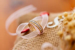 Alliance de mariage posé sur un écrin nature avec un ruban blanc