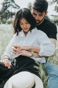 Couple dans les près se tenant la main après une demande en fiançailles