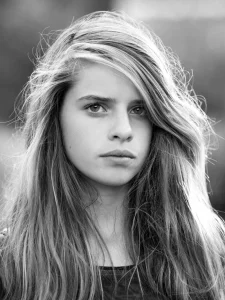 jeune femme qui pose avec un regard intérogatif du photographe devant un soleil couchant
