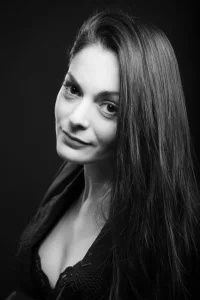 portrait d'un photographe pro en studio d'une femme qui a la tete legerement penché sur le coté pour voir l'objectif du photographe