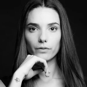 Portrait serré d'une femme en noir et blanc ou la femme se pose la tete sur le haut de ses doigts