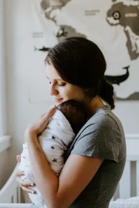 Maman qui tient son bébé dans les bras dans sa chambre